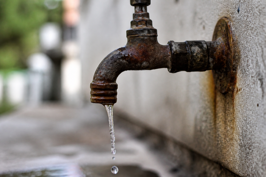 Eau s'echappant d'un robinet metallique rouille