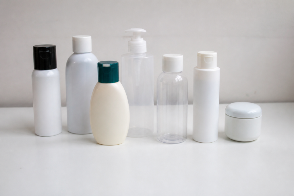 Flacons et contenants plastiques ranges sur plan blanc