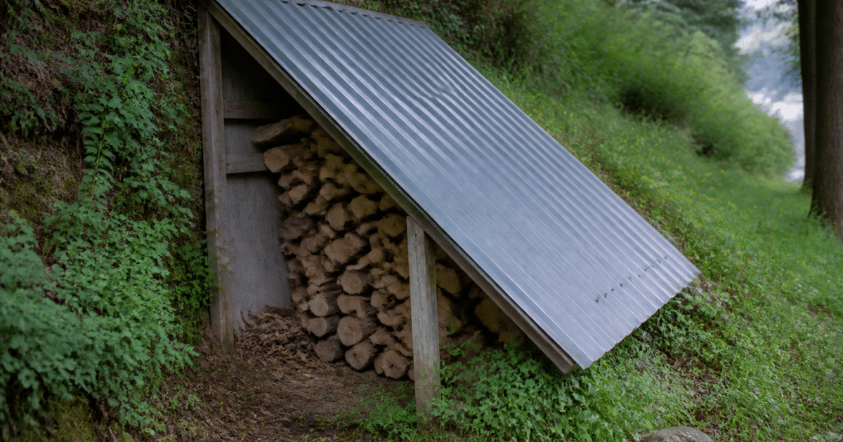 Structure metallique inclinee couvrant petit abri bois